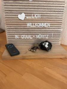 ein Handy auf einem Schild in der Unterkunft Ferienwohnung Bernsteinwind in Graal-Müritz