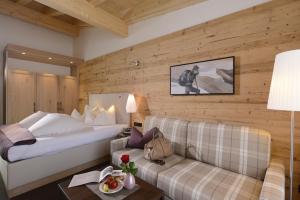 a hotel room with a bed and a couch at Hotel Weisses Lamm in See