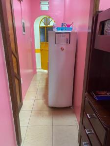 a pink kitchen with a refrigerator in a room at Apart Hotel - Alter Temporada in Manaus