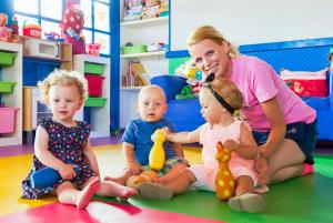 a woman and three children sitting on the floor in a room at H10 Suites Lanzarote Gardens in Costa Teguise