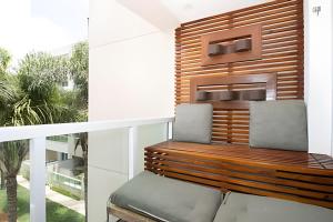 a balcony with two chairs and a wooden bench at Hotel Brisas do Lago Brasília - Ozped Flats in Brasilia