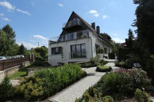 Cette maison blanche dispose d'une terrasse couverte et d'un jardin. dans l'établissement Pension Clajus, à Weimar