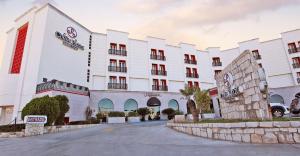 un gran edificio blanco con una calle delante en Hotel Colón Plaza Business Class, en Nuevo Laredo