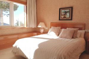 a bedroom with a large white bed with a window at Luxury Apartment Sierra Nevada in Granada