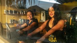 zwei Frauen, die vor einem Tresen in einem Laden stehen in der Unterkunft Kite Hotel Máncora - Beach & Gym in Máncora