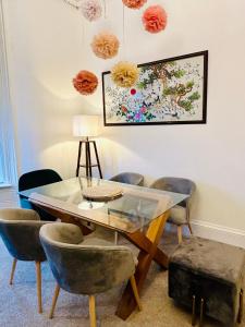 a dining room with a glass table and chairs at Glasgow Center/West End Apartment in Glasgow