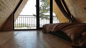 1 dormitorio con cama y ventana grande en Cottage 360°, en Surami