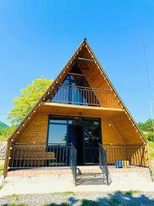 a large wooden house with a porch and a balcony at Cottage 360° in Surami