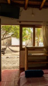 a bedroom with a bed and a view of a yard at Kite Hotel Máncora - Beach & Gym in Máncora