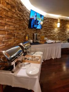 فندق بافيليون في بيهاتش: مطعم بطاولتين وتلفزيون على جدار من الطوب