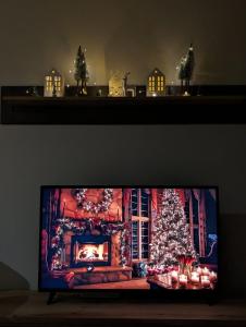 un televisor con un árbol de Navidad en una habitación en BratSki Apartman - 200m od gondole en Brzeće