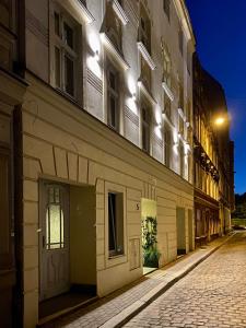 een lege straat 's nachts met een gebouw bij Wąska 5 Apartamenty in Wrocław