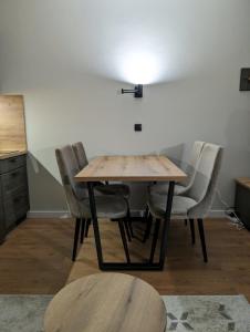 una mesa de comedor con sillas y una luz en la pared en BratSki Apartman - 200m od gondole en Brzeće