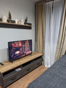 a room with a television on a wooden entertainment center at BratSki Apartman - 200m od gondole in Brzeće