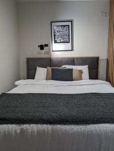 1 dormitorio con 1 cama grande con sábanas y almohadas blancas en BratSki Apartman - 200m od gondole en Brzeće