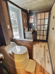 uma casa de banho com WC no meio de um quarto em Ranch de Frisons le Fer à Cheval - Le Madison - Chalet Rustchic au pied du Mont Mégantic em La Patrie