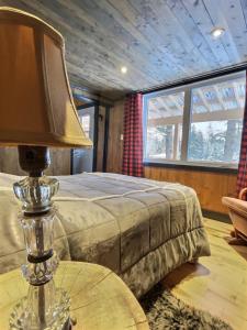 a bedroom with a bed and a lamp on a table at Chalet Le Madison Refuge nordique et ciel étoilé au pied du Mont-Mégantic in La Patrie +40 photos
