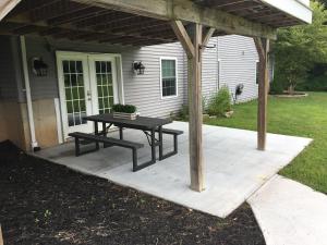 un patio con una mesa de picnic frente a una casa en Privacy, entertainment, comfort galore 2 BR LR 1BA Home Theater, Pool Table 