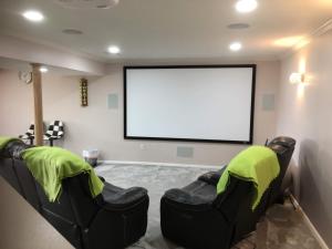uma sala de cinema com duas cadeiras em frente a um ecrã em Privacy, entertainment, comfort galore 2 BR LR 1BA Home Theater, Pool Table 