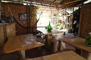 a room with wooden tables and benches and a brick wall at Hotel Imperio Copacabana in San Agustín