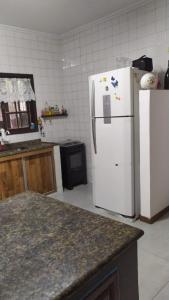 uma cozinha com um frigorífico branco e um balcão em Casa Barra do Jucu 50m da praia em Vila Velha