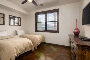 ein Schlafzimmer mit zwei Betten und einem Fernseher darin in der Unterkunft Luxury Downtown Rental (Hot Tub/Pet Friendly) - La Dolce Vita Villas #9 in Moab