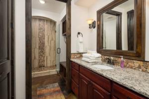 ein Badezimmer mit Waschbecken, Spiegel und Dusche in der Unterkunft Luxury Downtown Rental (Hot Tub/Pet Friendly) - La Dolce Vita Villas #9 in Moab + 17 Fotos