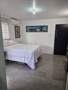 a bedroom with a white bed and a tile floor at Amharic in Kingston