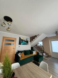 a living room with a green couch and a staircase at Apartament Janusza in Gronków