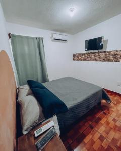 a bedroom with a bed and a tv on the wall at Bonito departamento y centrico in Lázaro Cárdenas