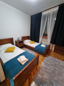 a hotel room with two beds and a window at Hotel Paviljon in Bihać