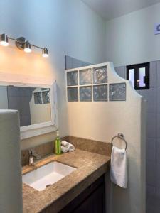 een badkamer met een wastafel en een spiegel bij Encantador loft 1 frente a plaza in Loreto