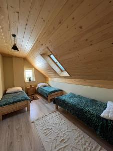 a attic room with two beds and a skylight at Apartament Janusza in Gronków