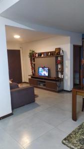 salon z kanapą i telewizorem w obiekcie Casa Barra do Jucu 50m da praia w mieście Vila Velha