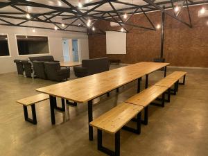 una sala de reuniones con mesas y sillas de madera en CASA RURAL ARENALINA, en Casas de los Pinos