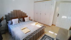 una camera da letto con un grande letto con due cuscini sopra di Welcome Home a Beni Mellal