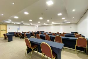 an empty lecture room with tables and chairs at Hotel Lets Ideia Brasília - Ozped Flats in Brasília