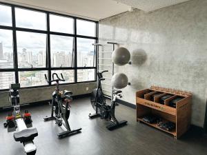 a gym with exercise bikes in a room with windows at STAY ID Vida Urbana in Goiânia