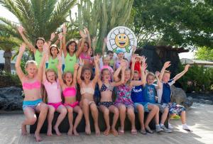 a group of children posing for a picture at a pool at H10 Suites Lanzarote Gardens in Costa Teguise