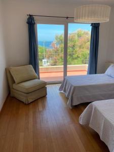 a bedroom with a bed and a chair and a window at Casa De Alta Categoría Ubicada En Barrio Medanos Frente Al Mar in Necochea