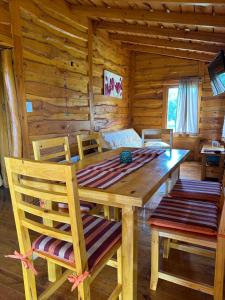 a wooden dining room table and chairs in a log cabin at Guanumby Cabañas in Tandil