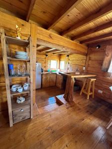 a large kitchen with a table in a log cabin at Guanumby Cabañas in Tandil