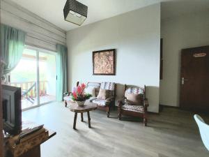 a living room with two chairs and a tv at My Paradise in Baie Lazare Mahé