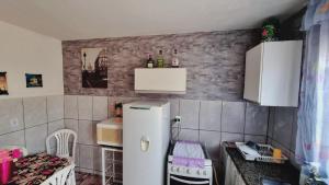 een kleine keuken met een witte koelkast en een tafel bij Kitnet confortável em paulinia in Paulínia