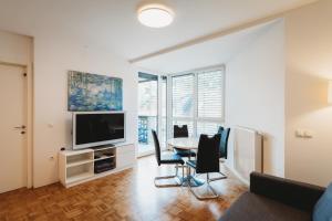 a living room with a table and a tv at Peaceful Little Retreat, spacious free garage park in Ljubljana