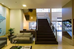 a living room with a staircase and a couch at OZPED Flats Particulares Edifício Monumental Nobile Suites in Brasilia