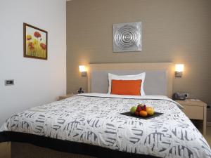 
a bed with a white comforter and pillows at IN Hotel Beograd in Belgrade
