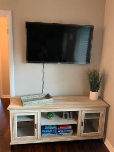 a flat screen tv on top of a wooden entertainment center at *3 blocks from AT&T Stadium* 2 bedroom-sleeps 6 in Arlington