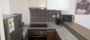 a kitchen with a stove and a microwave at Apart Hotel Castellon 176 in Concepción