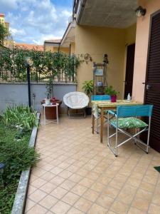 eine Terrasse mit einem Tisch, Stühlen und einem Zaun in der Unterkunft Casa~Lu in Mentana